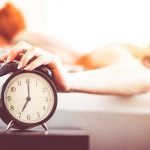 Woman Shutting Off Ringing Alarm Clock