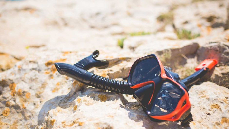 Snorkel and Diving Scuba Mask On a Rock Near The Sea