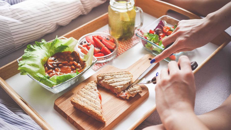 Young Woman Enjoying Morning Breakfast in Bed